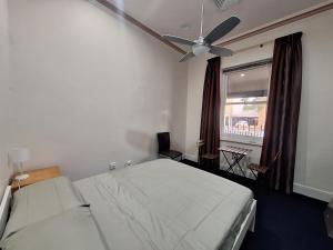 a bedroom with a bed and a ceiling fan at Adelaide Free Souls in Adelaide