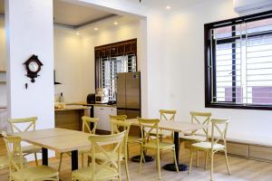 ein Zimmer mit Tischen und Stühlen sowie einer Küche in der Unterkunft Anna Home Ninh Binh in Kỳ Vĩ