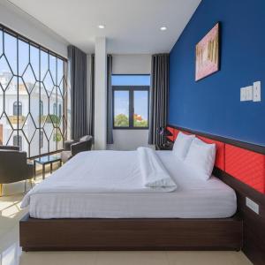 a bedroom with a large bed with a blue wall at Hưng Phú Hotel HCM in Ho Chi Minh City