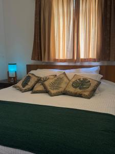 ランバリにあるApartamento aconchegante em condomínio encantador.のベッド(緑の毛布、枕付)