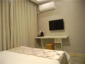 Una televisión o centro de entretenimiento en Shell Jiaxing Nanhu District Dongsheng Dong Road Moon River Street Hotel