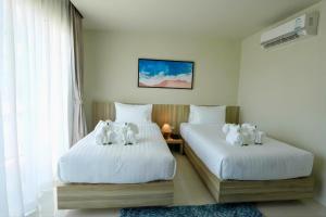 twee bedden met knuffels in een slaapkamer bij Aqua Maya Phuket in Patong Beach