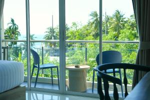 een kamer met 2 stoelen en een tafel op een balkon bij Aqua Maya Phuket in Patong Beach
