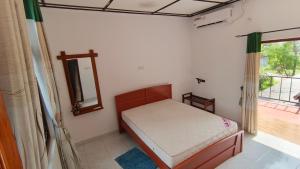 een kleine slaapkamer met een bed en een raam bij ISARA Guest in Polonnaruwa