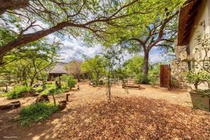 Niani villa في هويدزبروت: حديقة بها مقاعد وأشجار ومبنى +17 صورة