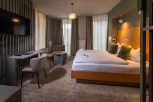 a hotel room with a large bed and a desk at Hotel Erbenhof in Weimar