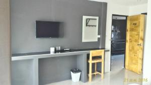 a room with a counter with a television on a wall at Loftel @ Nakhon in Nakhon Si Thammarat