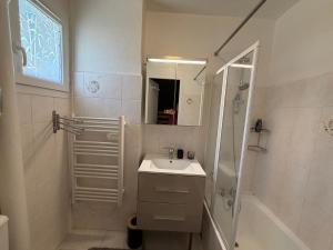 a white bathroom with a sink and a shower at Mimi lodge familly in Valloire