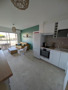 a kitchen with white appliances and a living room at T2 cosy proche de Nice - a 2 min à pied de la plage in Cagnes-sur-Mer