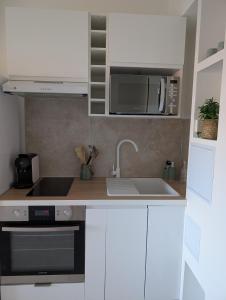 a kitchen with a sink and a microwave at T2 cosy proche de Nice - a 2 min à pied de la plage in Cagnes-sur-Mer +21 photos