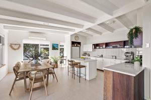 Una cocina y un comedor con mesa y sillas. en The Surf Nook - Walk to Beach - Family Friendly, en Gracetown