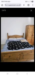 een slaapkamer met een bed met een houten bedframe bij 14 london road in Stonewood