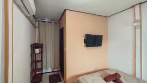 a room with a bed and a tv on the wall at ระเบียงพานโฮมสเตย์ ที่พักเกาะลิบง RabeangPhan Homestay Libong in Ko Libong