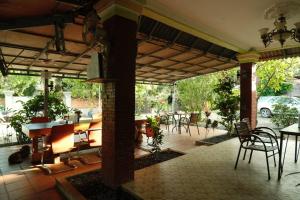 an open patio with tables and chairs and a car parked at Mabuhay Guesthouse Kampot in Kampot