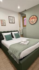a bedroom with a large bed with a clock on the wall at Le Mattoni 2 in Menton