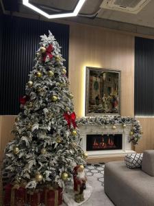 a christmas tree in a living room with a fireplace at Luxury City Apartments in Baku