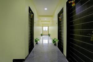 a hallway with two potted plants in a building at Hotel Om Sai residency in Taloje