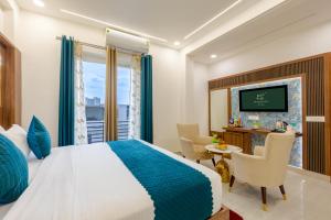 a bedroom with a bed and a desk and a television at Honeyveils Palace Hotel - Behind Indian Expo Mart in Greater Noida