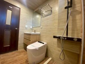 a bathroom with a toilet and a sink and a shower at Yunfeng Hotel 雲峰精品文旅 in Jinning