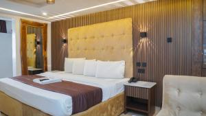 een slaapkamer met een groot bed en een stoel bij Presken Hotel Reliance, Allen, Ikeja, Lagos in Ikeja +31 foto's