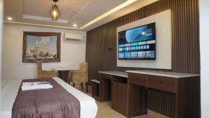 a hotel room with a bed and a flat screen tv at Presken Hotel Reliance, Allen, Ikeja, Lagos in Ikeja