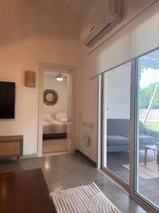 Una sala de estar con una puerta corrediza de vidrio que da a un dormitorio. en הבית של דובי, en Kfar Blum