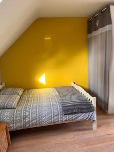 a bedroom with a bed with a yellow wall at Studio 61 in Angers