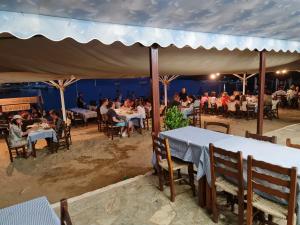 un grupo de personas sentadas en mesas en un restaurante en Katigiorgis Blue Hotel & Bungalow SPA Resort, en Agios Georgios