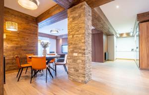 a dining room with a stone pillar and a table and chairs at NEO Skyview Suites in Gudauri