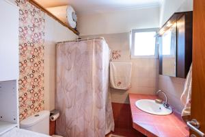 a bathroom with a sink and a shower curtain at Miraluna View in Mesochórion +28 photos