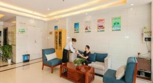 a man and woman standing in a living room at GreenTree Inn Qufu High Speed Railway Station in Qufu