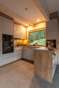 a kitchen with white cabinets and a large window at Zielone Wzgórze Sidzina in Sidzina