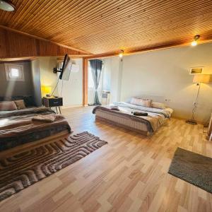 a large bedroom with two beds and a wooden ceiling at JD Maisonette for 4 in Neoi Epivates +6 photos