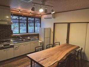 Una cocina con una mesa de madera y un refrigerador. en Villa KUMANO, en Hongū