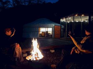 a group of people sitting around a fire at みどりの村 in Ogano