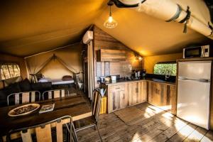 a kitchen and dining area of a tiny house at Camping 3 étoiles - Piscine - ccbccbe in Sartène