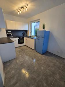 een keuken met een blauwe koelkast in een kamer bij Nestwerk Solide L16-02 in Biberach an der Riß +3 foto's