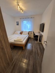 een slaapkamer met een bed en een bureau met een computer bij Nestwerk Solide L16-02 in Biberach an der Riß