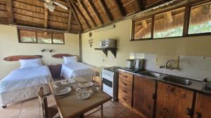 a kitchen with two beds and a sink in a room at Lush Horizons Game Lodge in Modimolle
