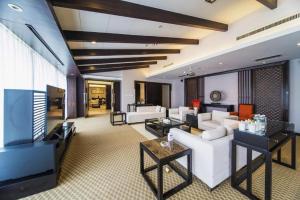 a living room with a white couch and a tv at International Conference Hotel Nanjing in Nanjing