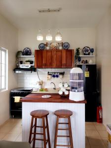 Villa Izabella in Panglao Island في داويس: مطبخ به سطح عمل مع كرسيين ومطبخ sidx sidx sidx