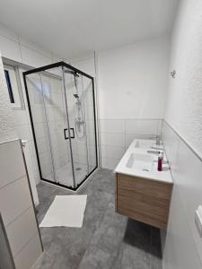 een badkamer met een glazen douche en een wastafel bij Nestwerk Solide L16-02 in Biberach an der Riß