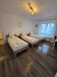 twee bedden in een kamer met houten vloeren bij Nestwerk Solide L16-01 in Biberach an der Riß