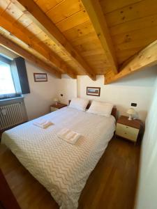 a bedroom with a large bed with wooden ceilings at Mansarda Residenza Giada in Pila