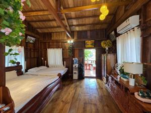 a bedroom with two beds in a wooden cabin at Cat Tien Vista in Tân Phú