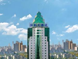 Un edificio alto con un cartel encima. en Hubei Poly Hotel, en Wuhan