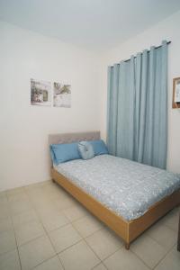 Villa Izabella in Panglao Island في داويس: غرفة نوم بسرير وستارة زرقاء