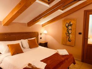 a bedroom with a large white bed with orange pillows at Hotel Lion in Roure Turin