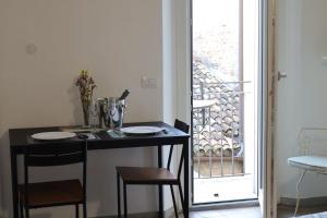 een kleine keuken met een tafel en stoelen naast een raam bij BELLA PRIMO PIANO in Forlì +7 foto's