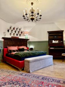 a bedroom with a bed and a couch and a chandelier at der Elbe so nah in Dömitz +25 photos